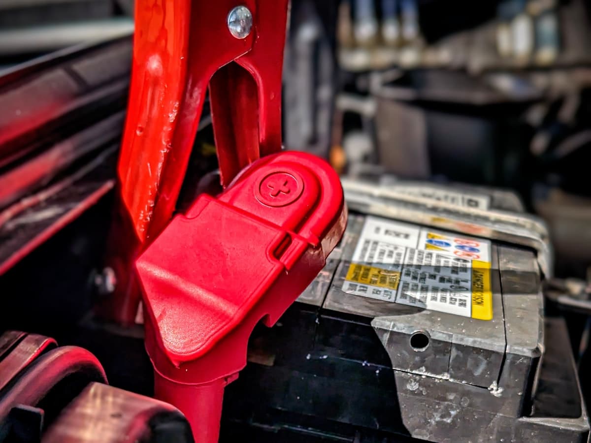 A car battery and jump-start clamp under the bonnet