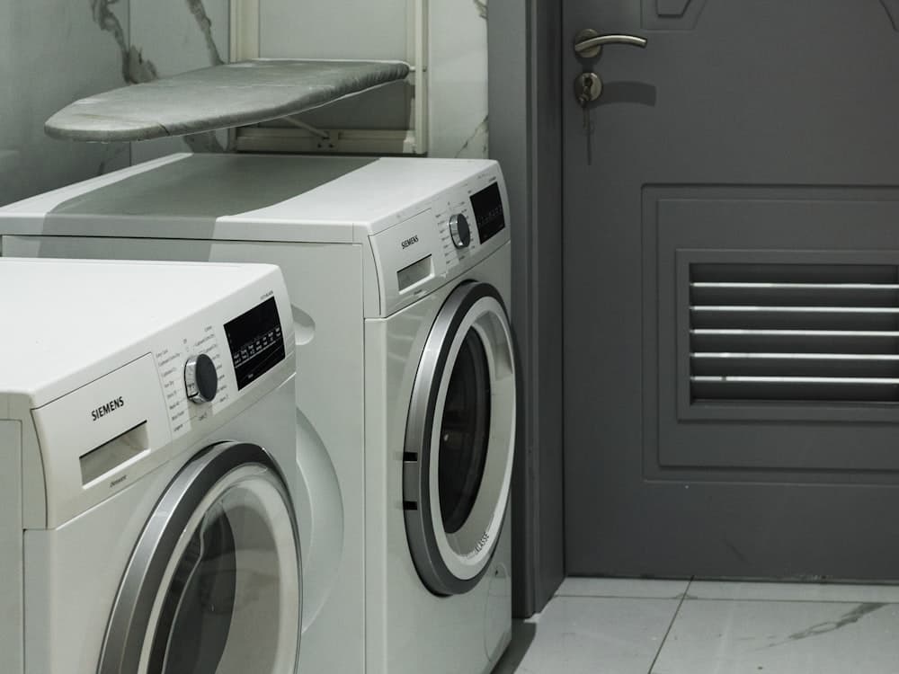 A washing machine and tumble dryer side by side in a laundry room